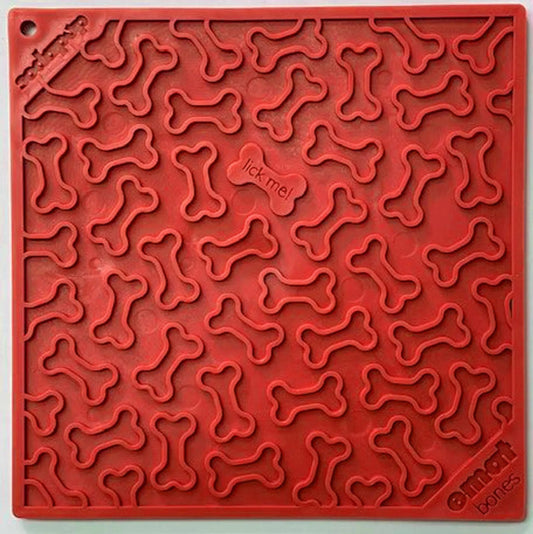 Red SodaPup Bones silicone lick mat with raised bone texture and 'lick me' center