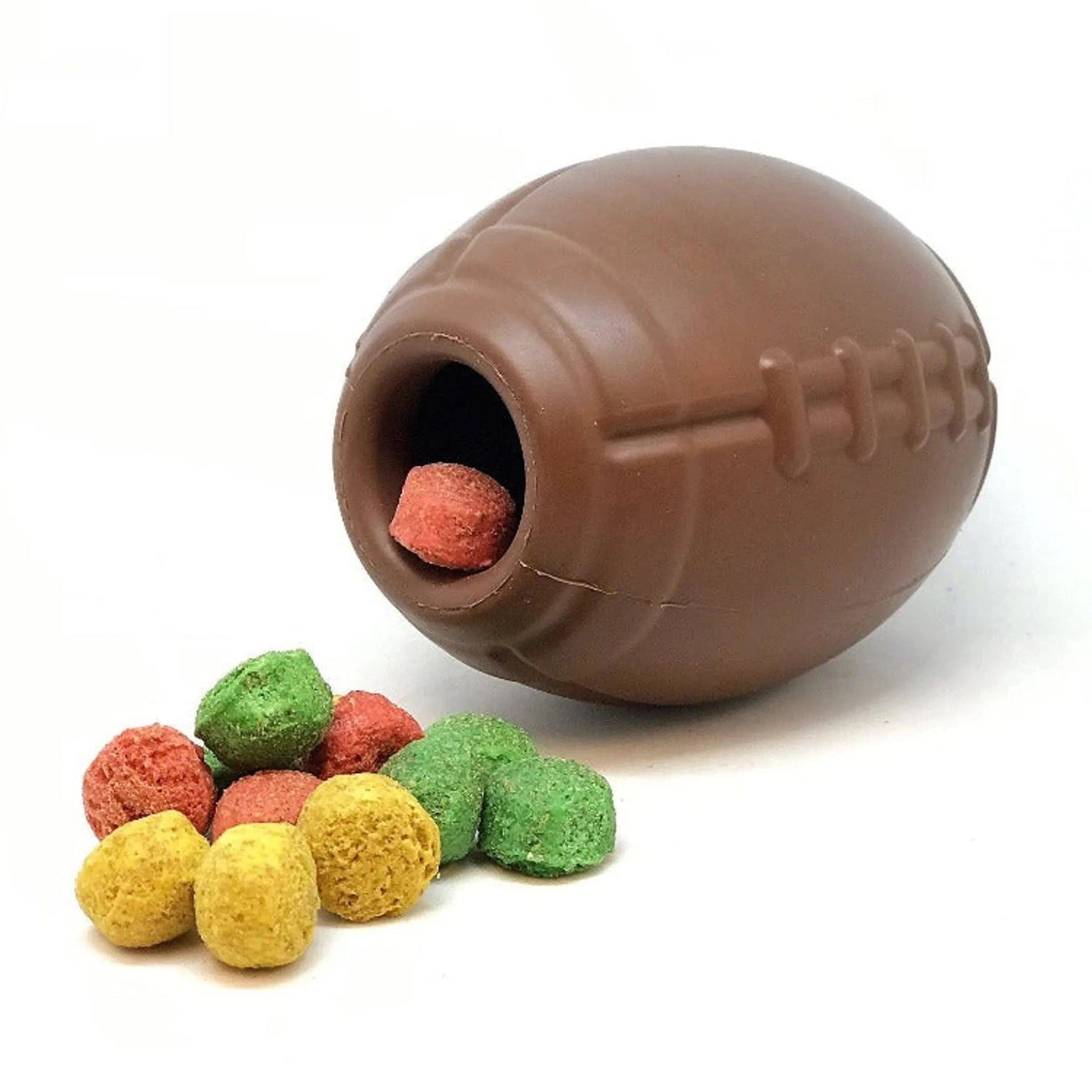Football-shaped rubber treat dispenser holding red cube treat with scattered balls