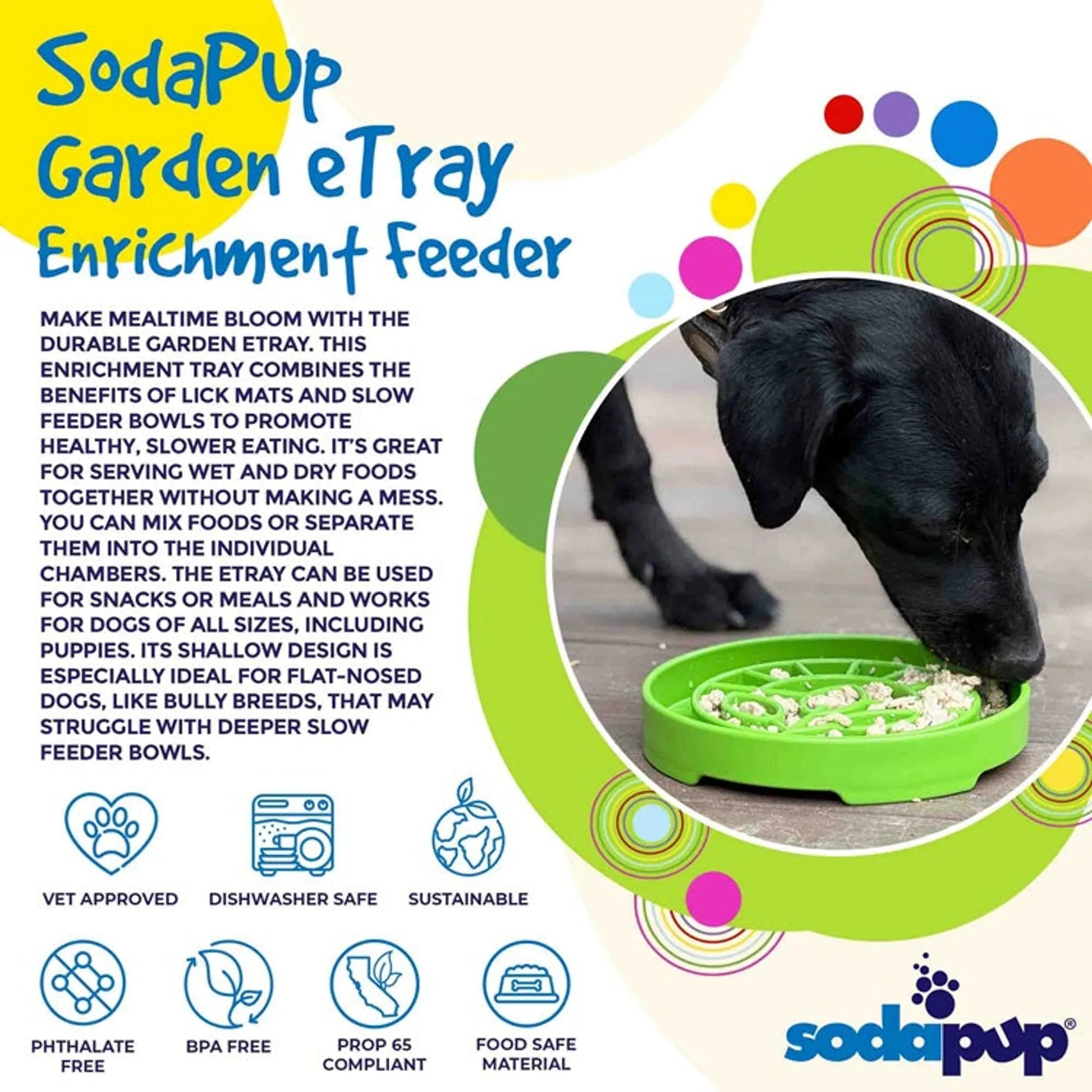Black dog eating from green SodaPup garden enrichment feeder on deck