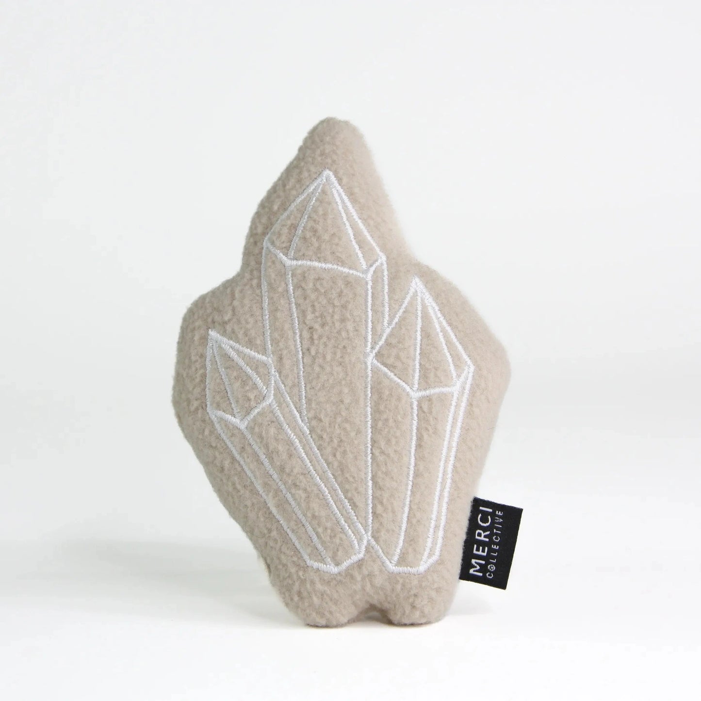 Beige plush crystal cat toy featuring embroidered geometric outlines and brand tag