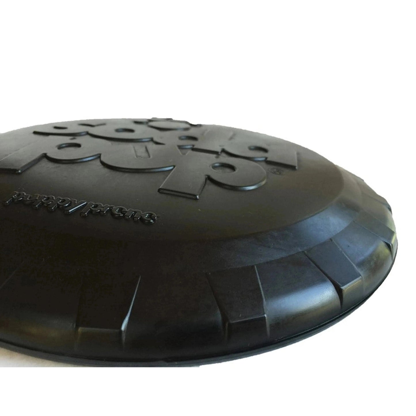 Side profile of black rubber dog frisbee showing thickness and aerodynamic ridges