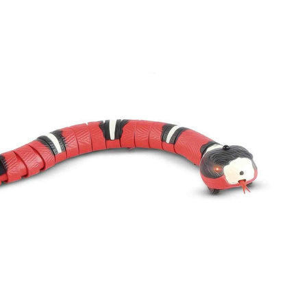 Side profile of red segmented snake toy showing scale texture and wheels