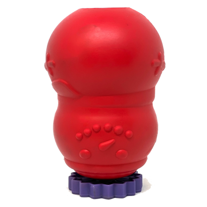Red rubber dog toy standing upright on a purple flower-shaped SodaPup stopper stand to prevent messy liquid leaks during prep